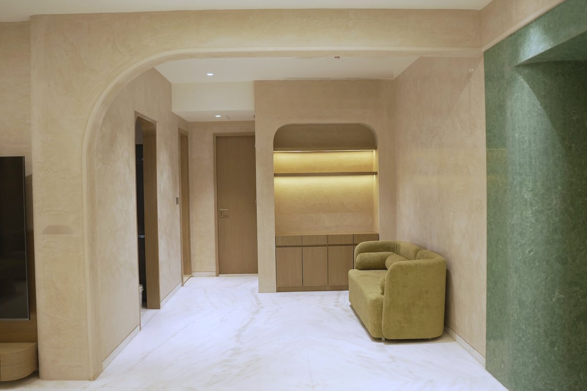 Sunlit plaster wall with a stone vase and wooden bench