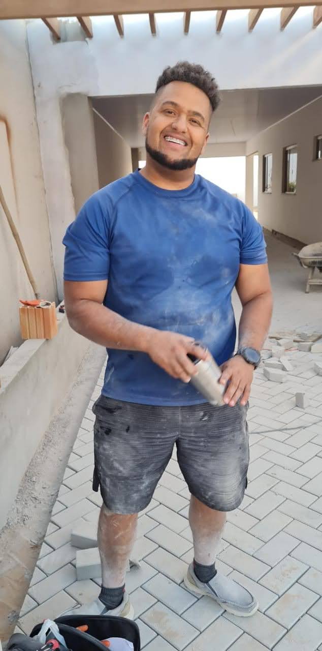 Weliton DeOliveira working in construction laying brick pavers