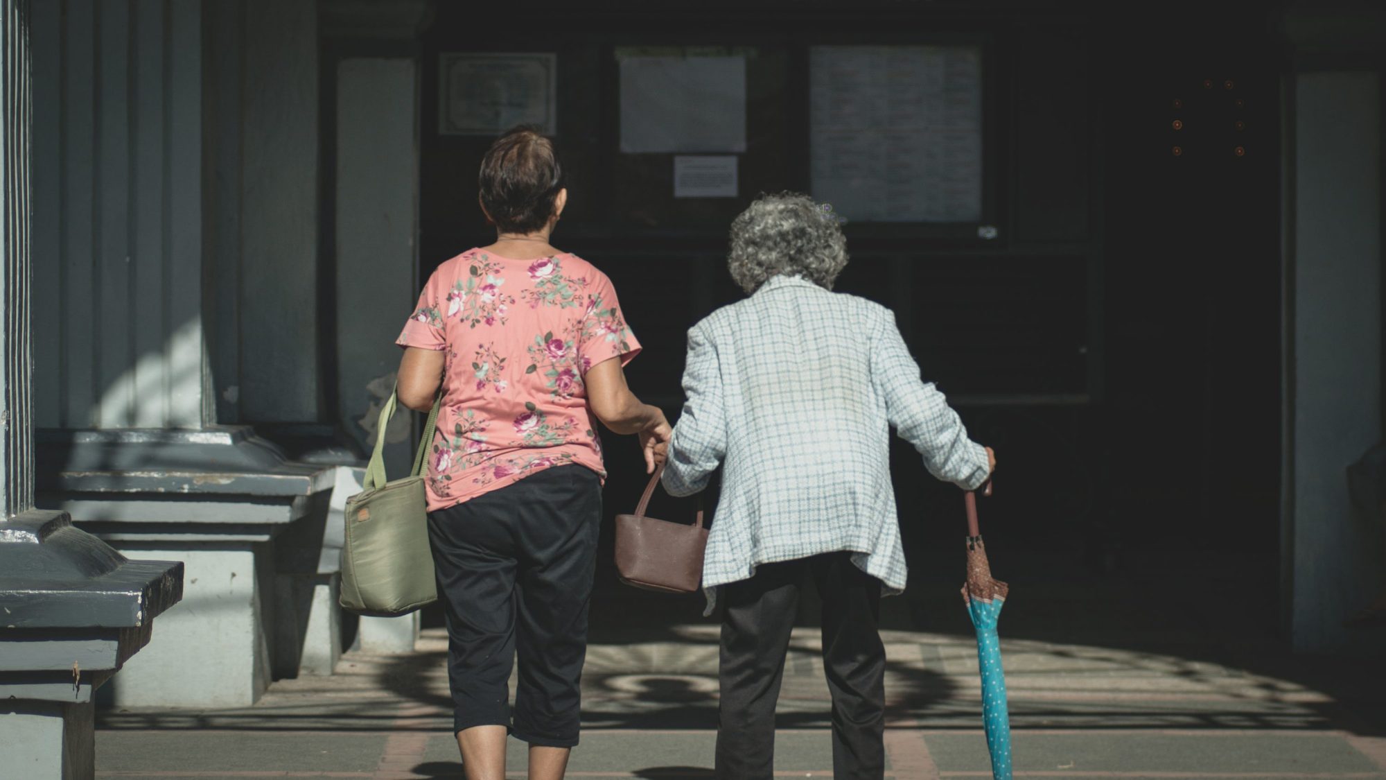 Caregiver standing with a senior resident