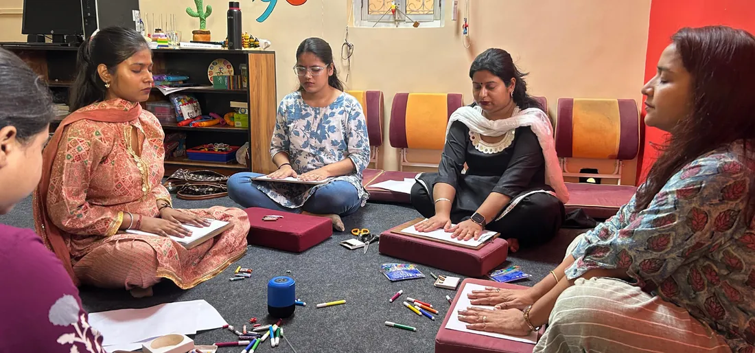 Teachers on cushions during an experiential Kosha Shiksha activity