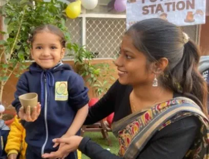 A child at a pottery station with a teacher